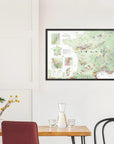 The De Long Wine Map of France Framed hangs above a dining table set with chairs, a vase, and glassware.