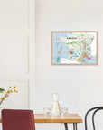 A dining area with a wooden table, chairs, and a De Long Wine Regions of France Vino One Framed map on the wall.