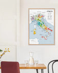 A De Long Wine Regions of Italy Vino One Framed map hangs above a dining table with chairs, a vase, and glassware.