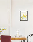 Minimalist dining area with wooden table, red chair, and De Long Cuis Premier Cru, Côte des Blancs map on white wall.
