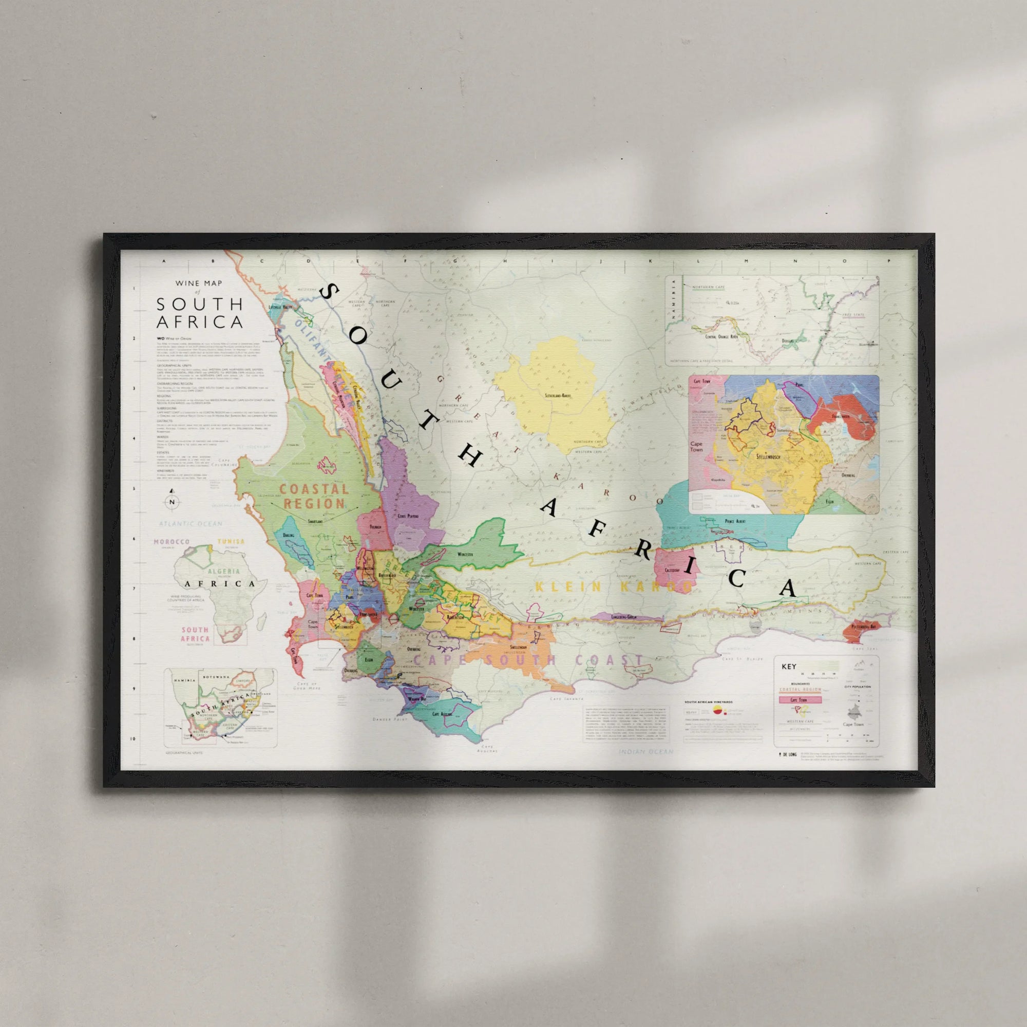 De Long's Wine Map of South Africa Framed hangs on a light wall, soft shadows highlighting its detailed regions.