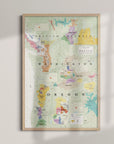 The Wine Map of the Pacific Northwest Framed features colorful sections and labels for Oregon and Washington wine regions, displayed on a light wall with soft shadows and a wood frame.