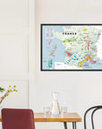 A De Long Wine Regions of France Vino One Framed map hangs above a dining table set with glassware and a plant.