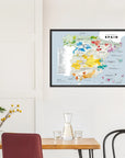 A De Long Wine Regions of Spain Vino One Framed print hangs above a minimal dining table with chairs.